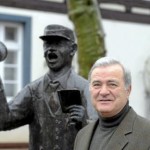 Wicker Hans-Bernd Allendorff Darauf ist er stolz: Hans-Bernd Allendorff vor der Figur des Ausschellers an der Sparkasse. Die Figur wurde 2003 auf sein Betreiben aufgestellt. Foto: Nietner