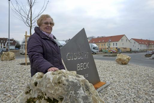 Liesel Beck, die Witwe des 1983 von einem Amokläufer ermordeten Polizisten Gisbert Beck, freut sich über das neu installierte Namensschild auf dem Kreiselbauwerk vor den Flörsheimer Kolonnaden. Foto: Hans Nietner